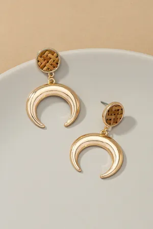 Metal horn drop earrings topped by a woven rattan disk